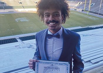 Jacob Patton holds a certificate that names him the recipient of a scholarship