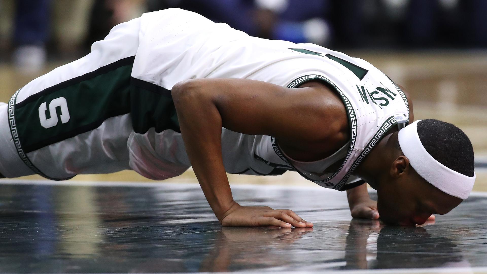 Cassius Winston kisses Spartan helmet on Breslin Center court